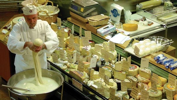 An Uncle Giuseppe employee making cheese fresh