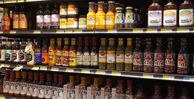 Different brands of BBQ sauce on a shelf.