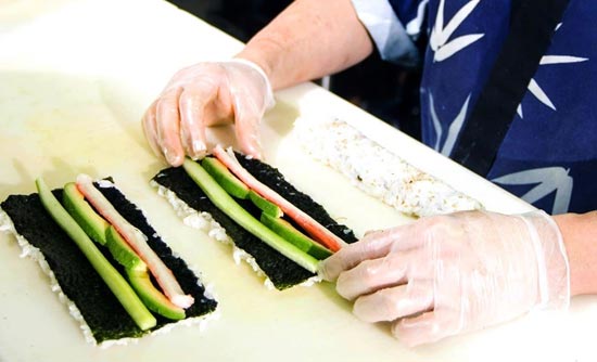 A sushi chef preparing a roll