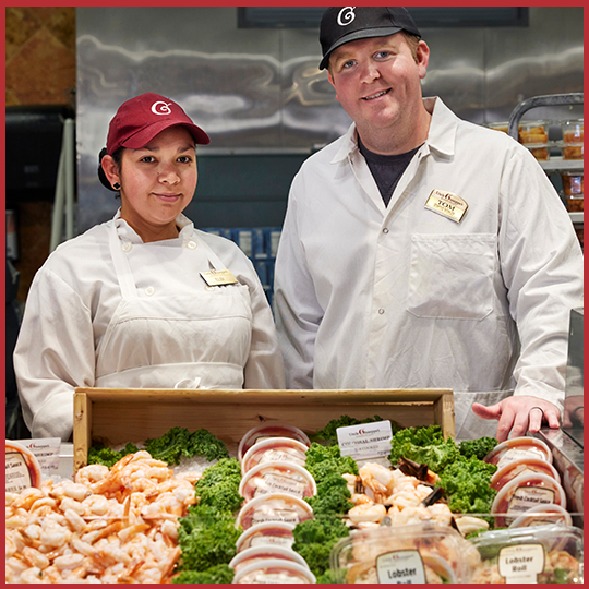 Two Uncle Giuseppe's employees at the seafood counter