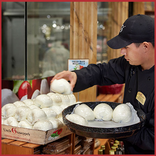 Uncle Giuseppe's associate stocking the fresh mozzarella