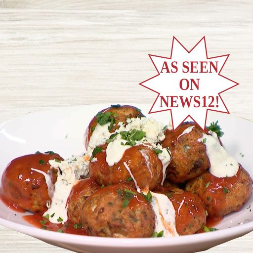 Buffalo chicken meatballs game day appetizer on white plate with hot sauce and blue cheese dressing garnish